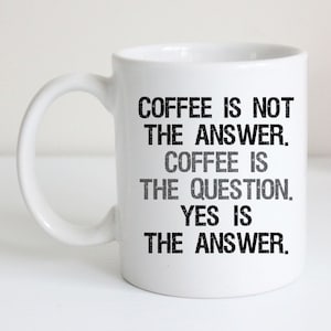 May include: White ceramic coffee mug with black text that reads "Coffee is not the answer. Coffee is the question. Yes is the answer."
