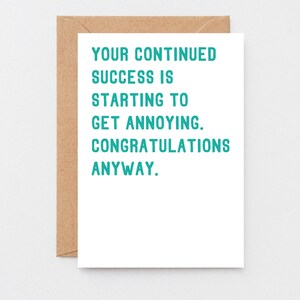 May include: A white card with teal text that reads "Your continued success is starting to get annoying. Congratulations anyway."