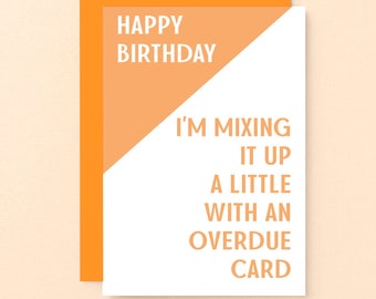 May include: A white card with orange text that reads "Happy Birthday. I'm mixing it up a little with an overdue card."