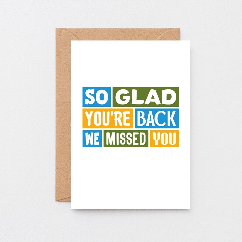 May include: A white greeting card with the message "SO GLAD YOU'RE BACK WE MISSED YOU" in blue, green, and yellow block letters. The card is inside a brown envelope.