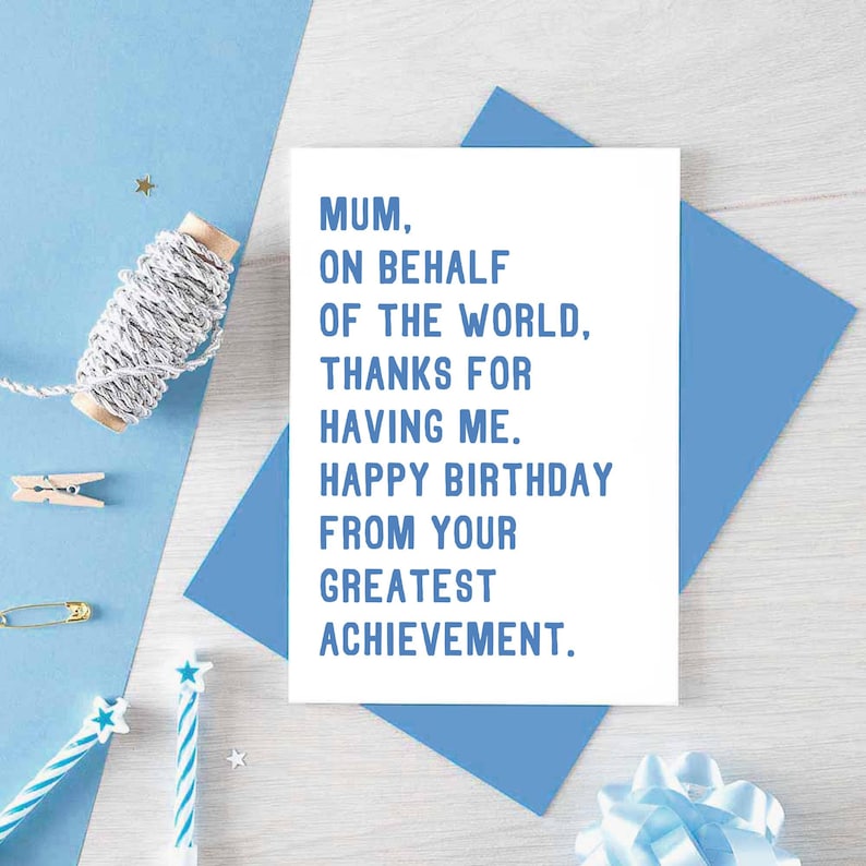 May include: A white card with blue text that reads "Mum, on behalf of the world, thanks for having me. Happy birthday from your greatest achievement."