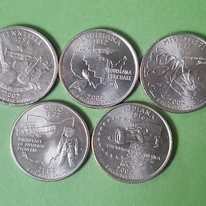 May include: Five silver US state quarter coins from 2002. The coins feature designs commemorating Tennessee, Louisiana, Mississippi, Ohio, and Indiana.