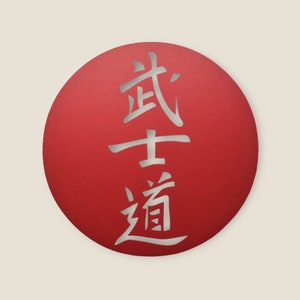 Puede incluir: Un círculo rojo con los caracteres japoneses para "Bushido" escritos en plata.