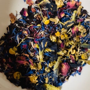 May include: A mix of dried flowers and herbs, including blue cornflowers, pink rose petals, yellow chamomile, and dark purple hibiscus.