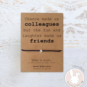 May include: A brown card with the text "Chance made us colleagues but the fun and laughter made us friends."  A blue string bracelet with a silver star charm is attached to the card. The card also has the text "Make a wish... as you place on your wrist" and "Bunny & Bee Gifts Handmade in the UK". A pink circle with a white bunny and bee logo and the text "ORIGINAL Bunny & Bee" is in the bottom right corner of the image.