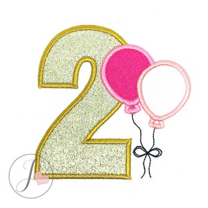 May include: Gold glitter number two with two pink and white balloons attached with a black ribbon.