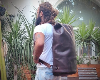 Könnte beinhalten: Eine braune Ledertasche mit einem langen Schultergurt. Die Tasche ist groß und hat ein schlichtes Design.