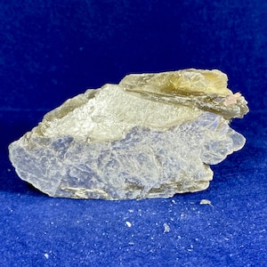 May include: A large, rough, light grey and brown rock with a layered, flaky texture. The rock has a natural, organic shape.
