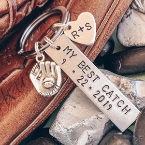 May include: Silver keychain with a baseball glove charm, a heart charm with the initials "R+S", and a rectangular tag that reads "My Best Catch 9.22.2019".
