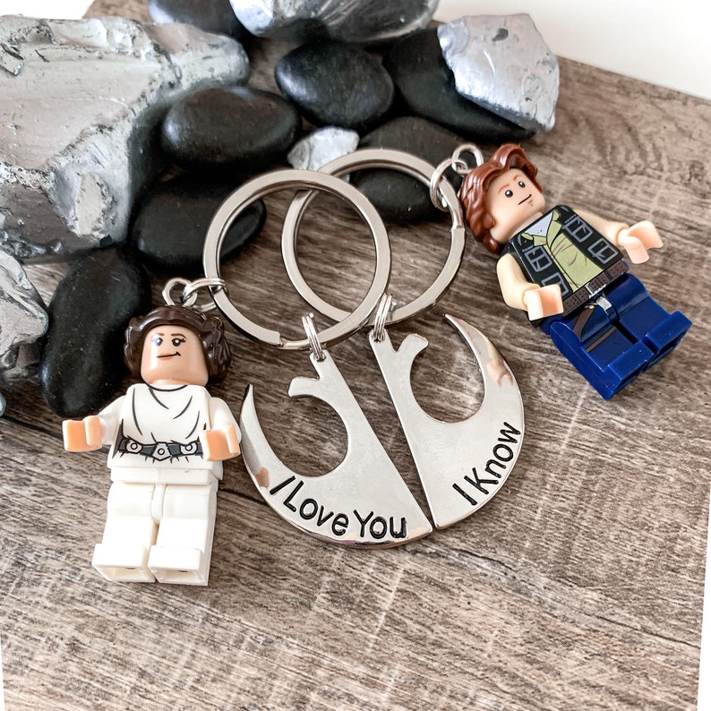 Pu&ograve; includere: Un paio di portachiavi argentati a forma di simbolo dell'Alleanza Ribelle di Star Wars. Un portachiavi dice "Ti amo" e l'altro dice "Lo so". I portachiavi sono attaccati a due piccole minifigure Lego, una di Principessa Leia e una di Han Solo.