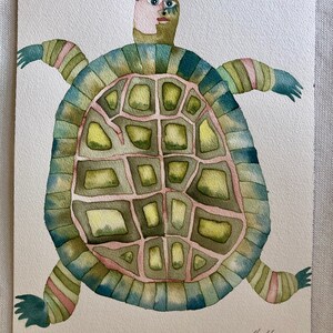 K&ouml;nnte beinhalten: Aquarellmalerei einer stilisierten Schildkr&ouml;te mit einem menschen&auml;hnlichen Gesicht. Der Panzer der Schildkr&ouml;te ist gr&uuml;n, blau und rosa mit einem geometrischen Muster. Das Gesicht der Schildkr&ouml;te ist in Rosa- und Braunt&ouml;nen gemalt.