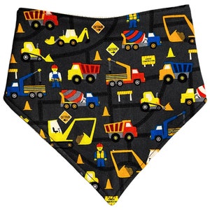 May include: A black bandana with a construction theme. It features yellow construction vehicles, cones, and road signs on a black background.