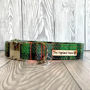 May include: Green and orange tartan dog collar with a silver buckle and a brown leather tag that reads "The Highland Hound".