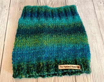 May include: A green and blue striped knitted dog collar with a brown leather tag that says "The Highland Hound".