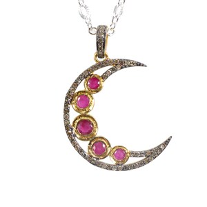 May include: A silver chain necklace with a crescent moon pendant. The pendant is adorned with five pink gemstones and small diamonds.