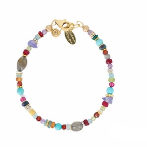 Puede incluir: Pulsera de cuentas multicolores con cierre dorado y una pequeña etiqueta que dice "Madeira Designs".