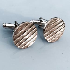 Handmade recycled cymbal and silver best man cufflinks.