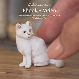 May include: A white miniature cat made of polymer clay, sitting on a wooden surface. The cat is about 1/12th scale and is being held by a finger. The image is for a tutorial on how to make a realistic miniature cat.