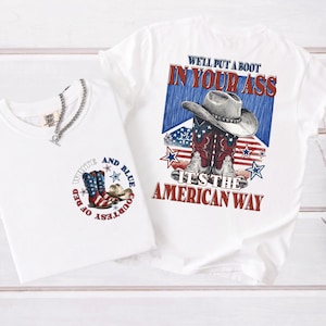 Puede incluir: Una camiseta blanca con un gráfico de botas vaqueras y un sombrero con patrones de la bandera estadounidense. El diseño trasero incluye el texto "WE'LL PUT A BOOT IN YOUR ASS IT'S THE AMERICAN WAY" y el frente dice "COURTESY OF RED WHITE AND BLUE".