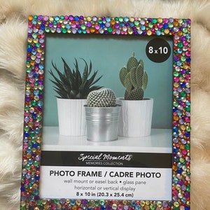 Könnte beinhalten: Ein rechteckiger Fotorahmen mit einem farbenfrohen, mit Juwelen besetzten Rand. Der Rahmen ist 8 x 10 Zoll (20,3 x 25,4 cm) groß und hat eine Glasscheibe. Der Rahmen ist mit "Special Moments" beschriftet und kann an der Wand befestigt oder auf einer Staffelei ausgestellt werden.