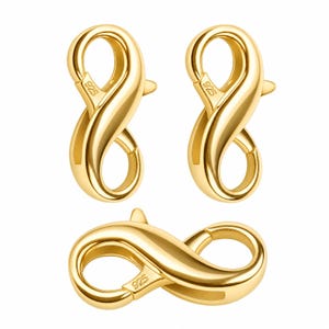 Pode incluir: Três fechos lagosta de metal dourado com um design liso e curvo. Cada fecho possui um mecanismo de mola e está claramente marcado com o texto 925, indicando a qualidade do metal. Dois estão orientados verticalmente e um horizontalmente.