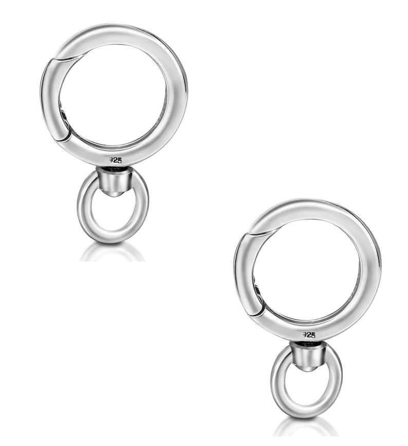 May include: Two silver-colored, round clasp connectors with a smaller ring attached below. The clasps are marked with "925". The connectors are designed to open and close, likely for attaching to jewelry or accessories.