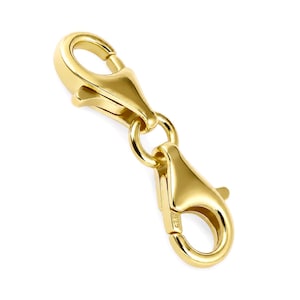 Könnte beinhalten: Ein goldfarbener Schmuckverschluss mit zwei Karabinerhaken, die durch einen zentralen Verbindungsring verbunden sind. Die Metalloberfläche ist glatt und reflektierend, wobei der Stempel 925 deutlich an der Seite eines Karabiners eingraviert ist.