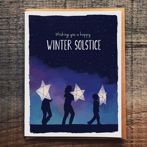 May include: A greeting card with a dark blue night sky background with white stars. The card says "Wishing you a happy Winter Solstice". Three silhouettes of people are walking, each carrying a white star lantern.