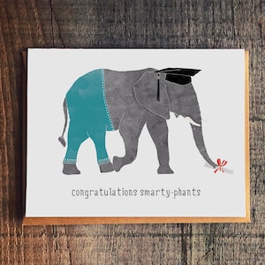 May include: A graduation card featuring a gray elephant wearing a blue graduation cap and gown, holding a red diploma. The card reads "congratulations smarty-phants".