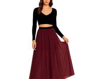 Puede incluir: Una mujer con un top negro de manga larga y una falda larga burdeos fluida. La falda tiene cintura alta y un dobladillo ancho. El conjunto es sencillo y elegante, adecuado para diversas ocasiones.