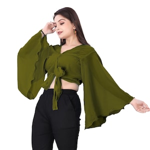 Puede incluir: Una blusa verde de manga corta, con lazada en el frente y mangas acampanadas. La blusa está hecha de una tela suave y fluida.