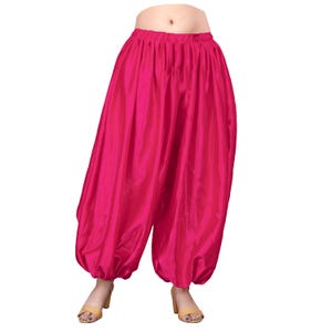 May include: Pink satin harem pants with a gathered elastic waistband.