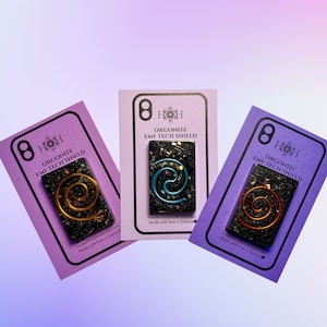 May include: Three purple cards with the text "8 HOH Orgonite EMF Tech Shield" and a black, gold, and blue orgonite pendant on each card. The text "houseofhollyhawk.etsy.com Made with love in Canada" is on each card.