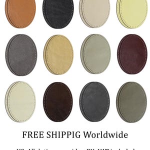 Puede incluir: Doce posavasos ovalados en varios colores, incluyendo marrón, negro y crema. Cada posavasos tiene un borde cosido. Los posavasos están dispuestos en una cuadrícula, mostrando una gama de tonos neutros.