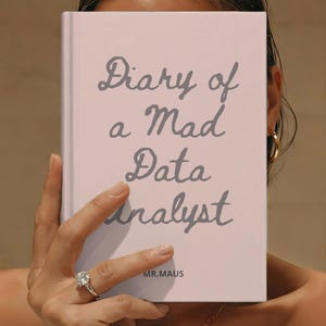 May include: A light pink hardcover book with the dark gray text Diary of a Mad Data Analyst printed on the front cover. The text MR.MAUS is printed in smaller dark gray letters near the bottom center of the book cover.