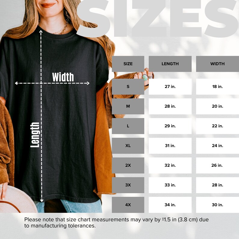 Może przedstawiać: Tabela rozmiar&oacute;w czarnego t-shirtu przedstawiająca długość i szerokość w calach dla rozmiar&oacute;w od S do 4X. Tabela zawiera długości od 27 do 34 cali oraz szerokości od 18 do 30 cali, z uwzględnieniem tolerancji produkcyjnej wynoszącej 3,8 cm.