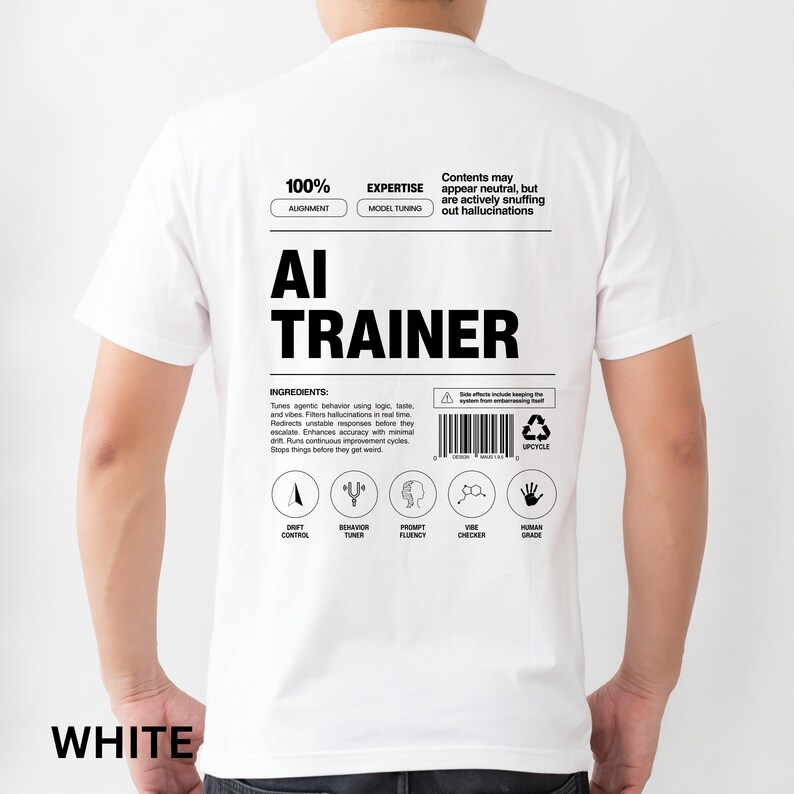 Model is wearing a white t-shirt shown from the back, displaying an AI Trainer parody label graphic designed like a tech product spec sheet with alignment indicators, ingredients, and dry humor.