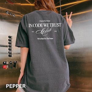 Puede incluir: Una taza de cerámica blanca con un asa negra y el texto "But First, Coffee" en un estilo manuscrito. La taza está sobre una superficie blanca. La taza mide aproximadamente 10 cm de alto.