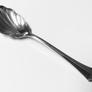 Puede incluir: Una cuchara de azúcar de plata con un cuenco festoneado y un mango adornado.