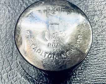 Crema facial de maquillaje en tarro pequeño con tapa, estilo vintage de Charles of the Ritz.