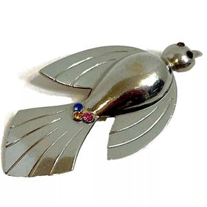 May include: Silver-toned bird brooch with a stylized design and a cluster of colorful rhinestones.