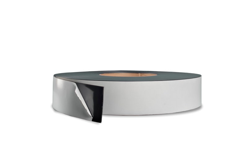 May include: A roll of white tape with a black backing. The tape is partially unrolled, revealing the adhesive side.