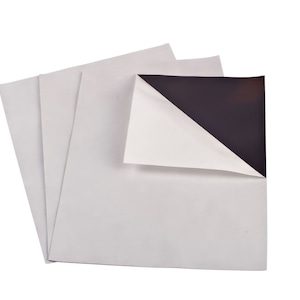 May include: Three sheets of white magnetic paper with one sheet partially peeled back to reveal the black magnetic backing.