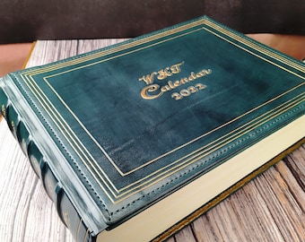 May include: A dark green leather-bound journal with gold accents and the text "W&T Calendar 2022" embossed on the front cover.