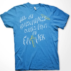 K&ouml;nnte beinhalten: Zwei T-Shirts mit dem gleichen Design, eines in Marineblau und eines in Cyan. Das Design zeigt ein wei&szlig;es Kreuz mit einem gelben Heiligenschein dar&uuml;ber und den Text "All my awesomeness comes from my Father" in Wei&szlig;.