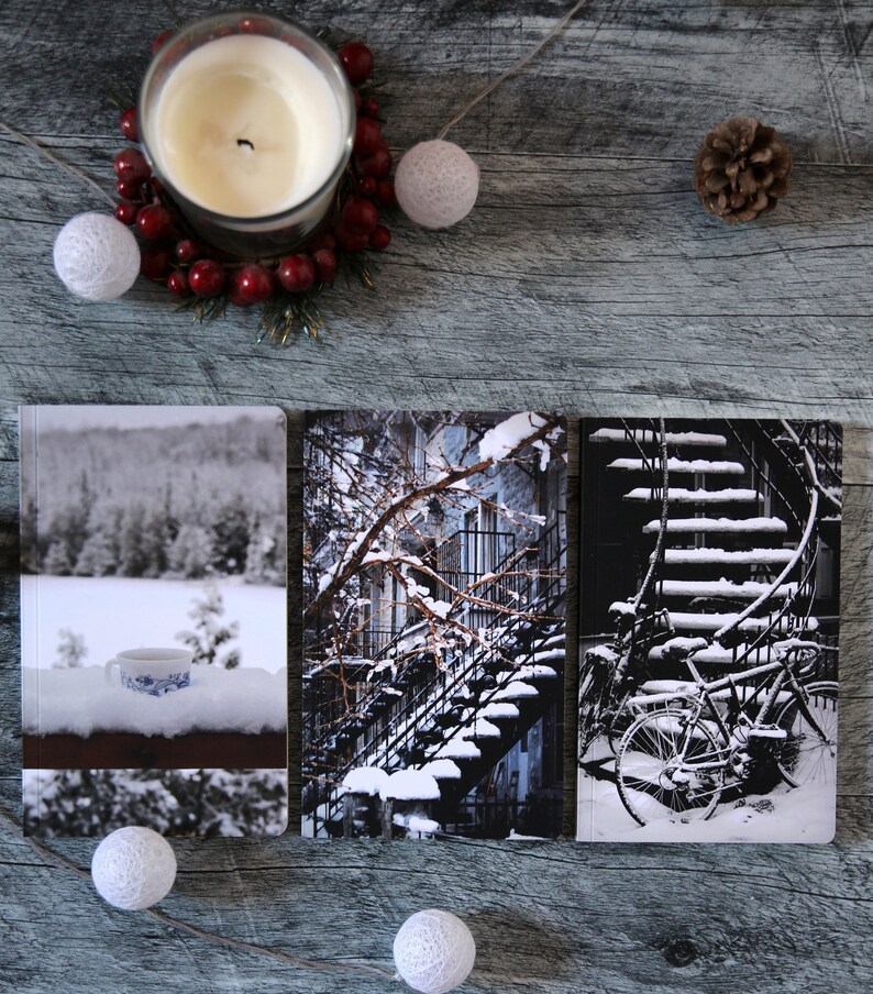 A trio of winter notebooks featuring a black and white photograph of Montreal's snow-covered spiral walk-up stairs with parked bicycles covered in snow. 

The hand-bound notebooks measure 5x8 inches. They contain 48 pages of cream-white acid free paper with a smooth finish. The matte cover is smooth and scuff-resistant!

Each notebook comes with an insert containing 15 insightful journaling prompts!