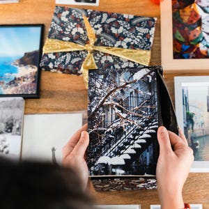 A winter notebook featuring a black and white photograph of Montreal's snow-covered spiral walk-up stairs with parked bicycles covered in snow. The notebook is surrounded by other Montreal notebooks and mini prints that can be framed or sent as cards.

The hand-bound notebooks measure 5x8 inches. They contain 48 pages of cream-white acid free paper with a smooth finish. The matte cover is smooth and scuff-resistant!

Each notebook comes with an insert containing 15 insightful journaling prompts!