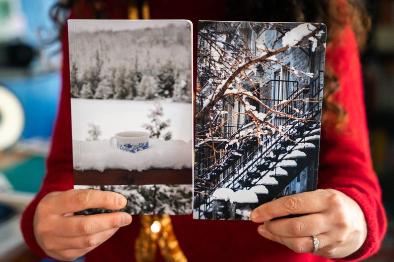 A duo of winter notebooks featuring a black and white photograph of Montreal's snow-covered spiral walk-up stairs with parked bicycles covered in snow. 

The hand-bound notebooks measure 5x8 inches. They contain 48 pages of cream-white acid free paper with a smooth finish. The matte cover is smooth and scuff-resistant!

Each notebook comes with an insert containing 15 insightful journaling prompts!
