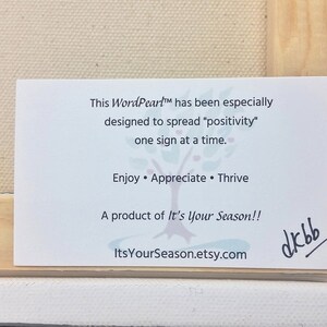 May include: White card with black text that reads "This WordPeart&trade; has been especially designed to spread "positivity" one sign at a time. Enjoy &bull; Appreciate &bull; Thrive A product of It's Your Season!! ItsYourSeason.etsy.com" with a handwritten signature that reads "dkbb".