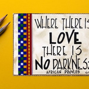 May include: A white canvas with a black and white African proverb that reads "Where there is love there is no darkness." The canvas is bordered with a colorful patterned fabric and has a "WordReads" logo in the bottom right corner.